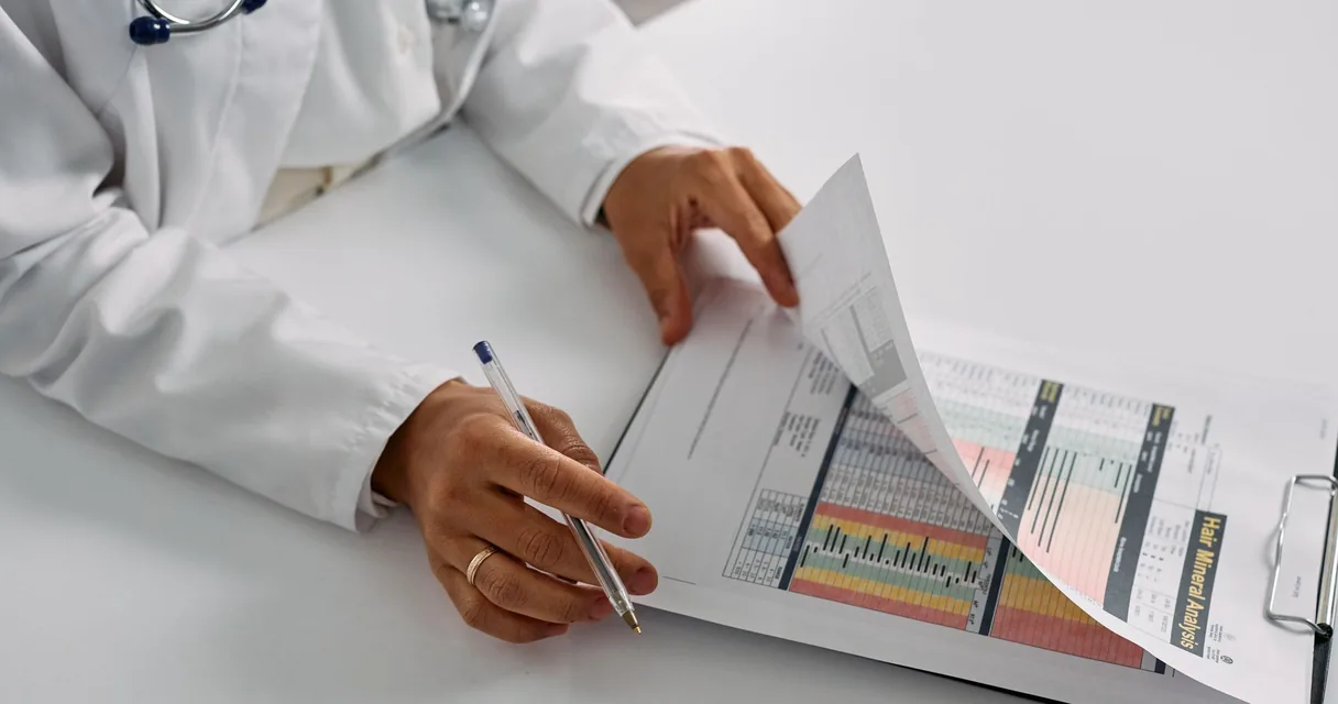 Médico preenchendo relatório em mesa de consultório